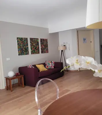 a living room with a purple couch and white flowers at Appartamento in centro Titi's place in Palermo