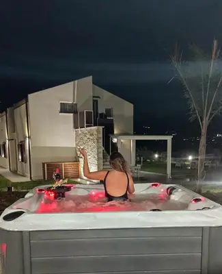 a woman sitting in a bath tub at night at Splendida Villa NATURE-APPARTAMENTO MELOGRANO a SCOPELLO-ZINGARO vista sul mare in Scopello