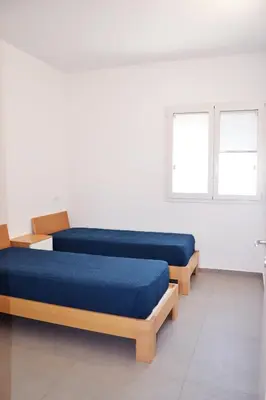 two beds in a white room with two windows at Splendida Villa NATURE-APPARTAMENTO MELOGRANO a SCOPELLO-ZINGARO vista sul mare in Scopello