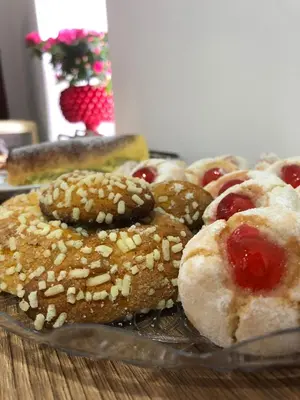 a glass plate of pastries with cherries on a table at nonno peppe in Palermo