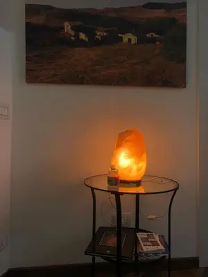 a table with a lamp on it next to a painting at nonno peppe in Palermo