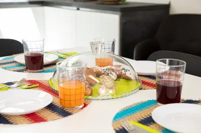 a table with a plate of food and glasses of juice at Splendida Villa NATURE- APPARTAMENTO ARANCIO a Scopello - Zingaro in Scopello
