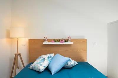 a bed with blue sheets and pillows in a bedroom at Splendida Villa NATURE- APPARTAMENTO ARANCIO a Scopello - Zingaro in Scopello