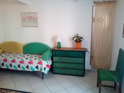 a bedroom with a bed and a dresser with a lamp at La Casetta di Dafne in Palermo