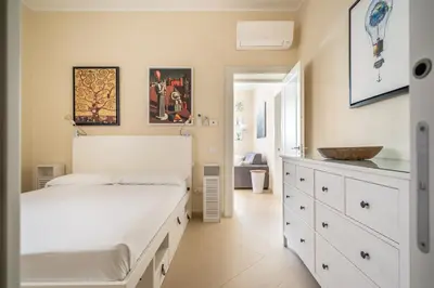 a bedroom with a white bed and a sink at L'Angolino di Anna in Mondello