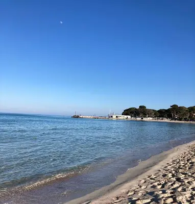 a beach with the ocean and buildings in the background at L'Angolino di Anna in Mondello