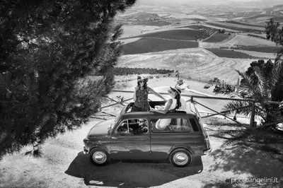 two women sitting on top of an old car at Agriturismo Antichi Granai in Calatafimi