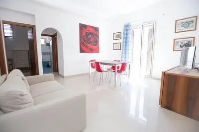 a white living room with a white couch and a table at Casa in centro in Castellammare del Golfo