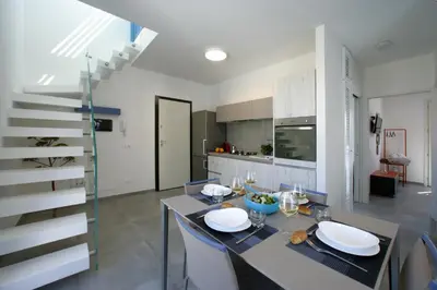 a kitchen and dining room with a table and a staircase at ITACA e MEDEA - Appartamenti con idromassaggio in terrazza in San Vito lo Capo