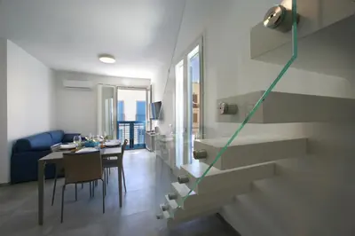 a living room with a dining table and a staircase at ITACA e MEDEA - Appartamenti con idromassaggio in terrazza in San Vito lo Capo