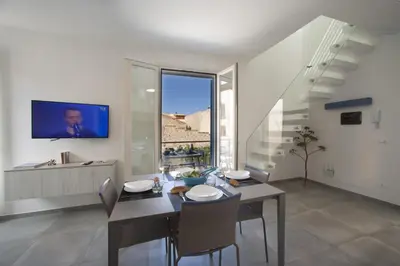 a dining room with a table and a tv on a wall at ITACA e MEDEA - Appartamenti con idromassaggio in terrazza in San Vito lo Capo