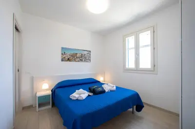 a bedroom with a blue bed and a window at ITACA e MEDEA - Appartamenti con idromassaggio in terrazza in San Vito lo Capo