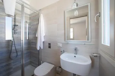 a bathroom with a sink and a toilet and a mirror at ITACA e MEDEA - Appartamenti con idromassaggio in terrazza in San Vito lo Capo