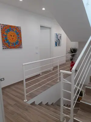 a white staircase with a painting on the wall at Bed and Breakfast Stella del Sud Makari in Macari