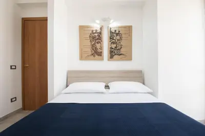 a bedroom with a bed and two pictures on the wall at Sea Vito Apartment in San Vito lo Capo