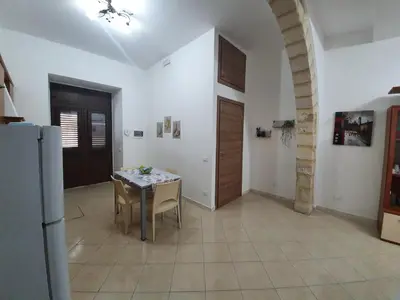 a kitchen with a table and a refrigerator in a room at Casa vacanza Corallo in Castellammare del Golfo