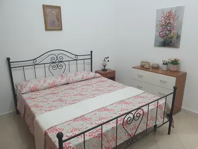 a bedroom with a bed with a floral bedspread at Casa vacanza Corallo in Castellammare del Golfo