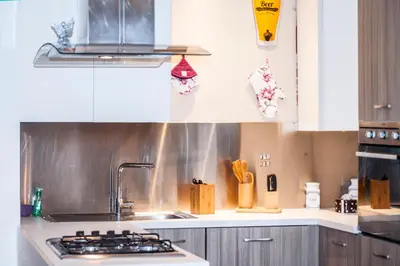 a kitchen with white cabinets and a stove top oven at Da Ale alla Cattedrale in Palermo