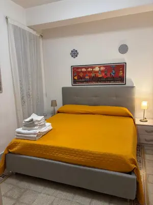 a bedroom with a bed with a yellow blanket at Casa di fronte la Cattedrale in Palermo