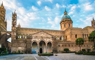 a large building with a clock tower on top of it at Casa di fronte la Cattedrale in Palermo