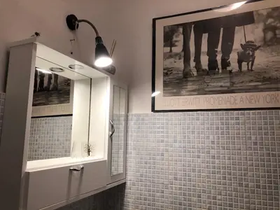 a bathroom with a mirror and a picture on the wall at Casa di fronte la Cattedrale in Palermo
