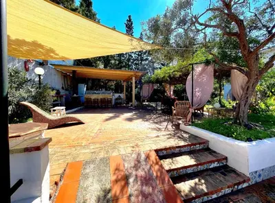 a patio with a yellow umbrella and a table and chairs at Villa dell’Orsa in Cinisi