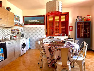 a kitchen with a table and chairs in a kitchen at Villa dell’Orsa in Cinisi