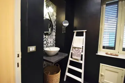 a black bathroom with a sink and a ladder at La Casetta 90139 in Palermo