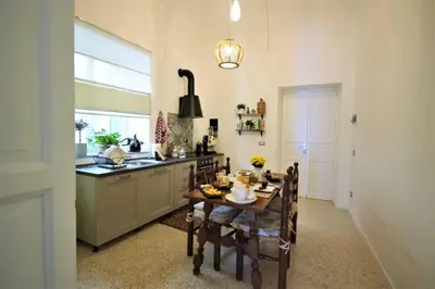 a kitchen with a table and chairs and a kitchen with a sink at La Casetta 90139 in Palermo