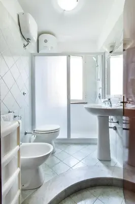 a white bathroom with a toilet and a sink at Case Vacanze Paradise Beach Vicino Cefalù PISCINA APERTA in Campofelice di Roccella
