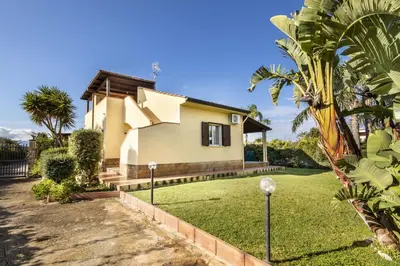 a house with a lawn in front of it at Case Vacanze Paradise Beach Vicino Cefalù PISCINA APERTA in Campofelice di Roccella
