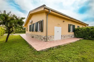 a small house with a white door in a yard at Case Vacanze Paradise Beach Vicino Cefalù PISCINA APERTA in Campofelice di Roccella