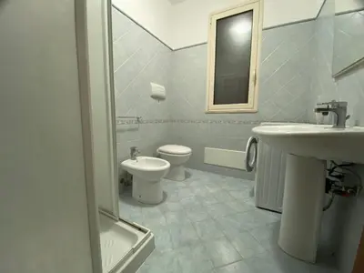 a white bathroom with a sink and a toilet at Case Vacanze Paradise Beach Vicino Cefalù PISCINA APERTA in Campofelice di Roccella