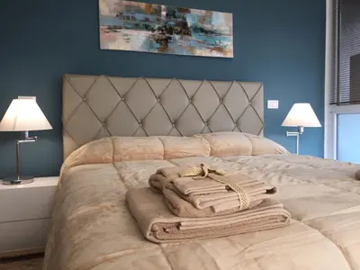 a bedroom with a bed with two towels and two lamps at George House Palermo in Palermo