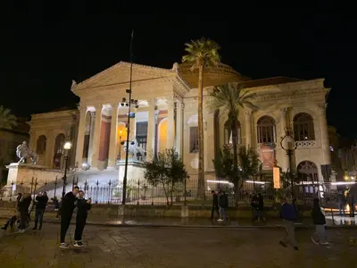 a building with people standing in front of it at night at George House Palermo in Palermo