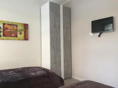 a bedroom with a bed and a tv on the wall at George House Palermo in Palermo