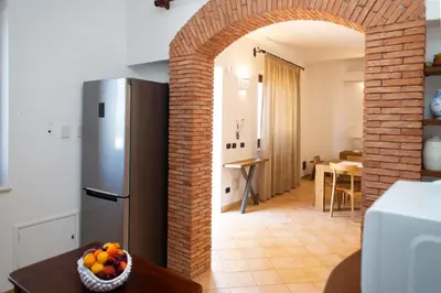 a kitchen with a refrigerator and a table with a bowl of fruit at Feudo Giglio Country Charme in Calatafimi