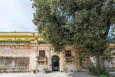 an old building with a tree in front of it at Loft Trinacria con Vista Mare by Wonderful Italy in Palermo