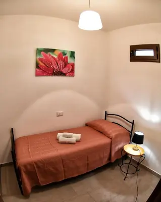 a bedroom with a bed and a painting on the wall at La Domus di Segesta in Calatafimi
