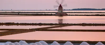 a windmill in the middle of a river with pink water at La Domus di Segesta in Calatafimi