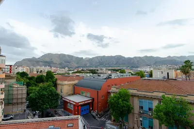 an aerial view of a city with mountains in the background at POLICLINICO HOME in Palermo