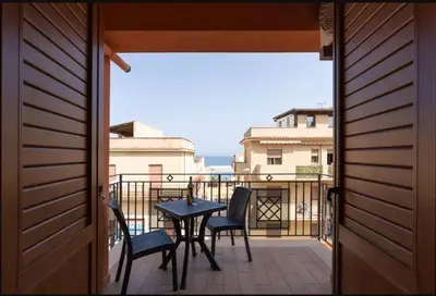 a patio with a table and chairs on a balcony at Azzurra Apartments in Balestrate