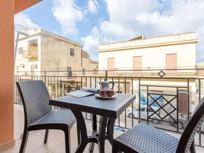 a table and chairs on a balcony with a view at Azzurra Apartments in Balestrate