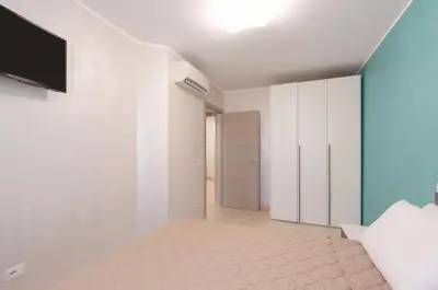 a room with white walls and a television on a wall at Azzurra Apartments in Balestrate