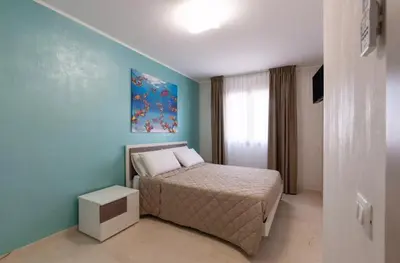 a bedroom with a bed and a blue wall at Azzurra Apartments in Balestrate