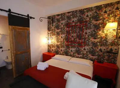 a bedroom with a bed and a wall with a floral wallpaper at Accardi House Searooms in Palermo