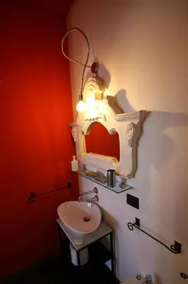 a bathroom with a sink and a light on the wall at Accardi House Searooms in Palermo