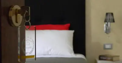 a bedroom with a bed with a red and white pillow at B&B Oreto Centro in Palermo