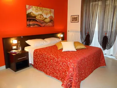a bedroom with a bed with an orange wall at B&B Oreto Centro in Palermo