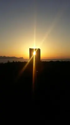 a sunset with the sun setting behind a building at Le Case Vacanze di Federico in Terrasini